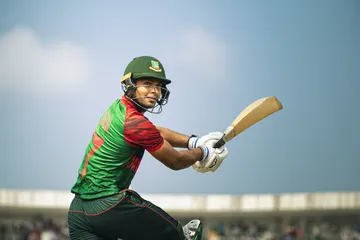 A man celebrating a winning moment on his laptop while gaming symbols float around him, capturing the excitement of 786BD games.